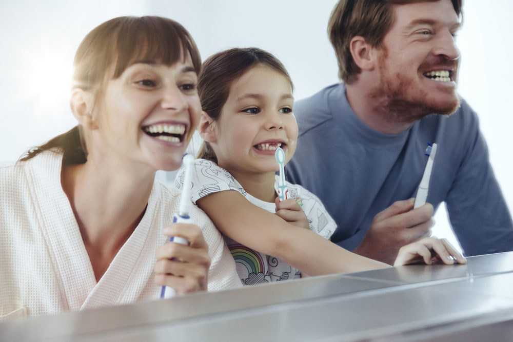 man and woman and child brushing teeth