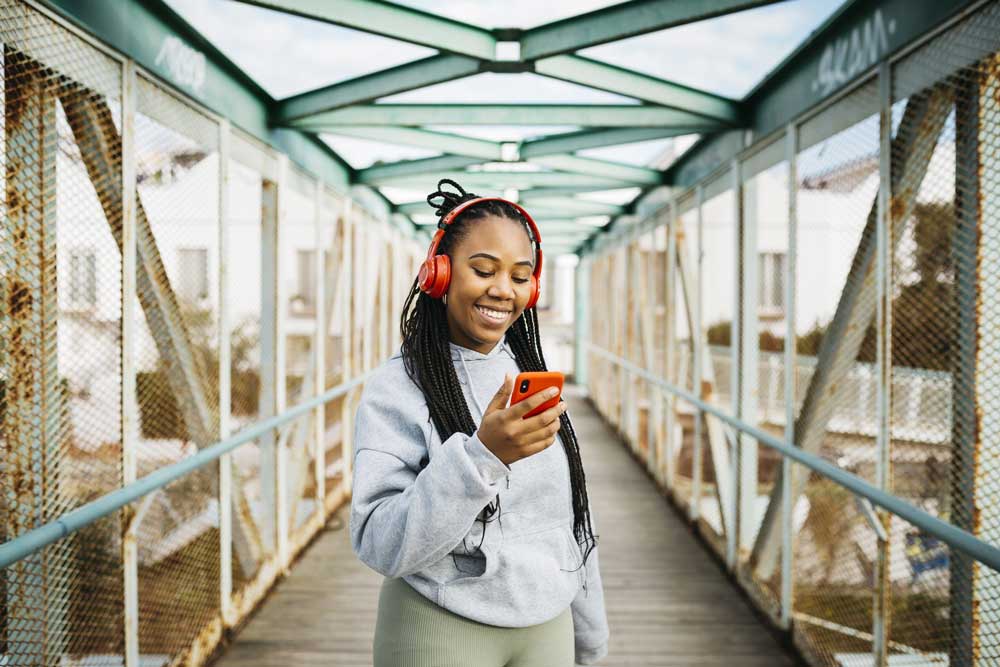 woman wearing headphones looking at phone