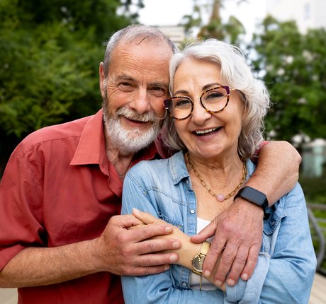 man and woman smiling for a picture in the woods