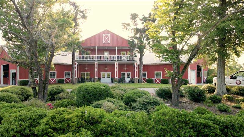 red barn building surrounded by trees