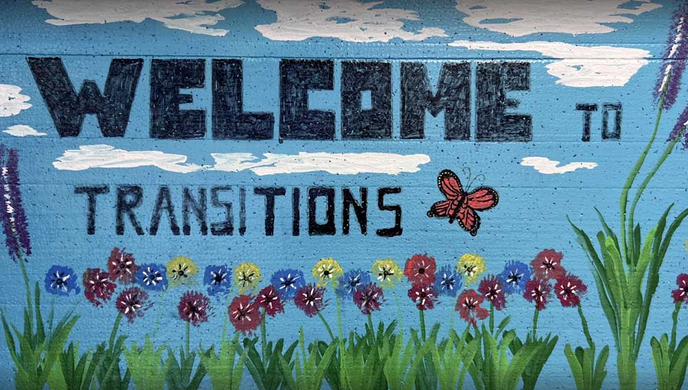 welcome to transitions mural with flowers and butterfly