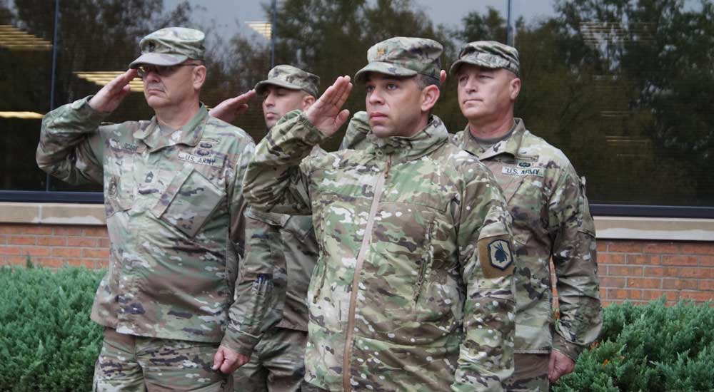 Group of men in military garb saluting 