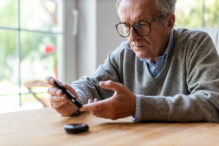 elderly man checks blood sugar