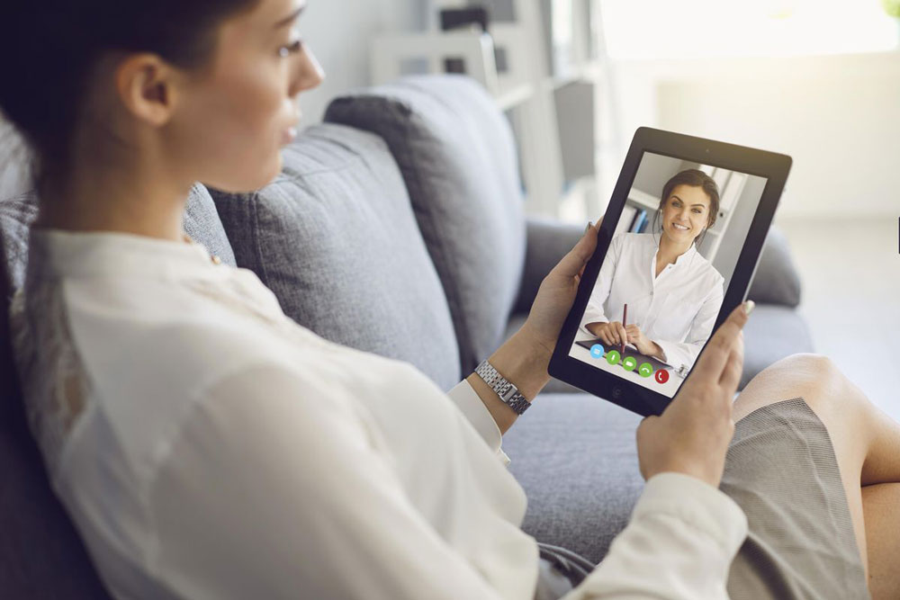 counselor talks with patient on tablet