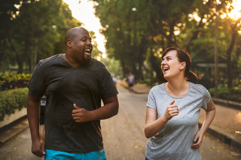 man and woman running in park 