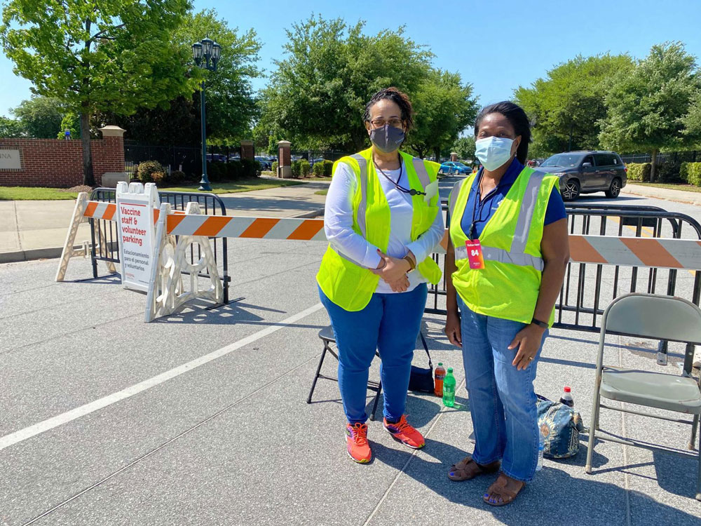 two women wearing masks outside at vaccination event
