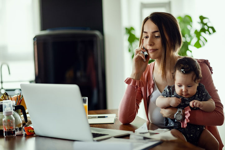 woman on phone with baby in arms