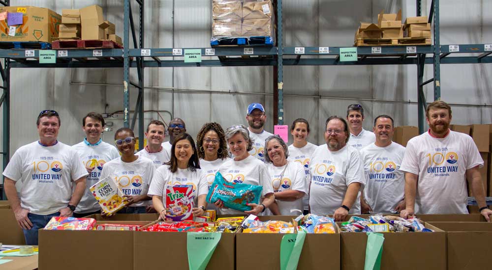 group of employees around cardboard boxes in warehouse