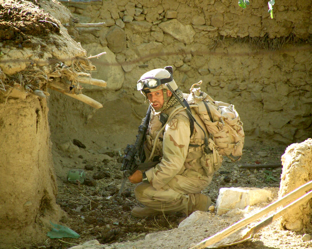 man in camo crouching 