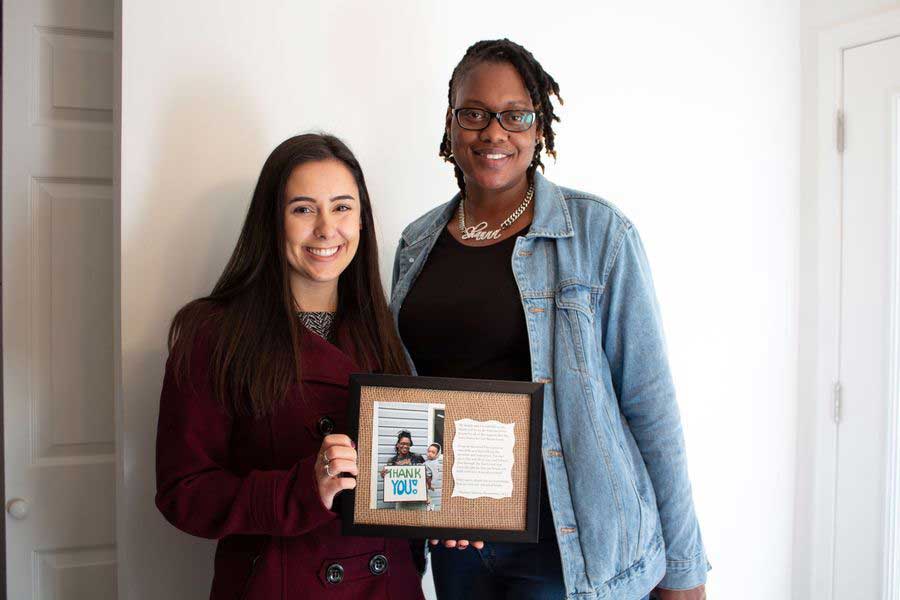 two women holding thank you note