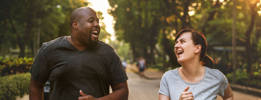 man and woman running in park