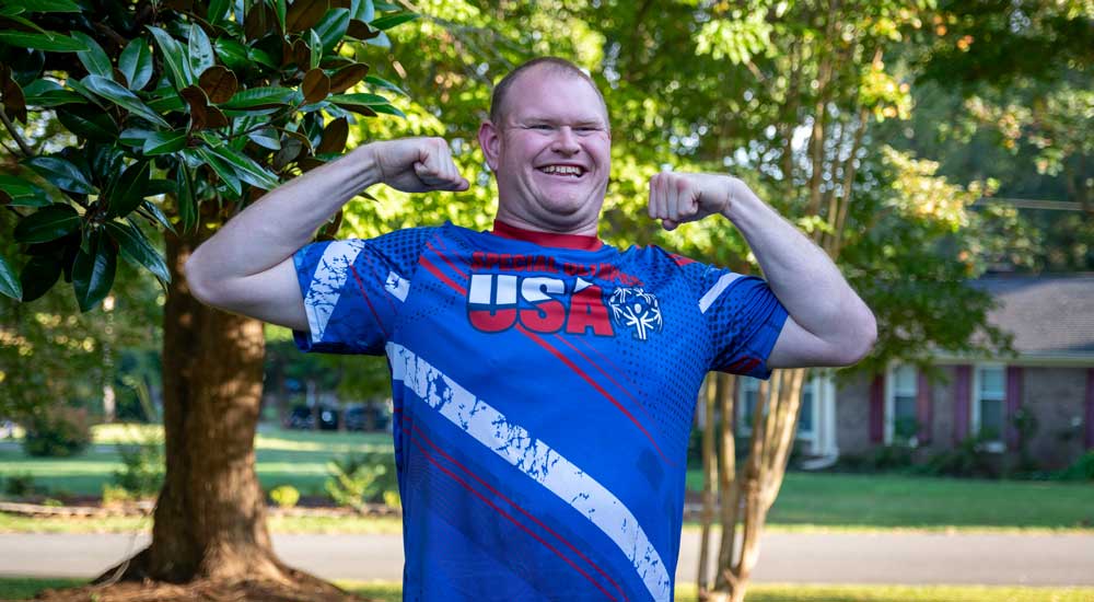 man wearing usa shirt holding up arms 