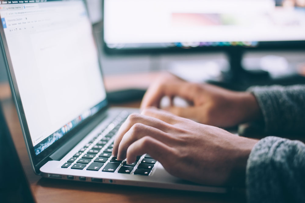 close up of computer with person typing