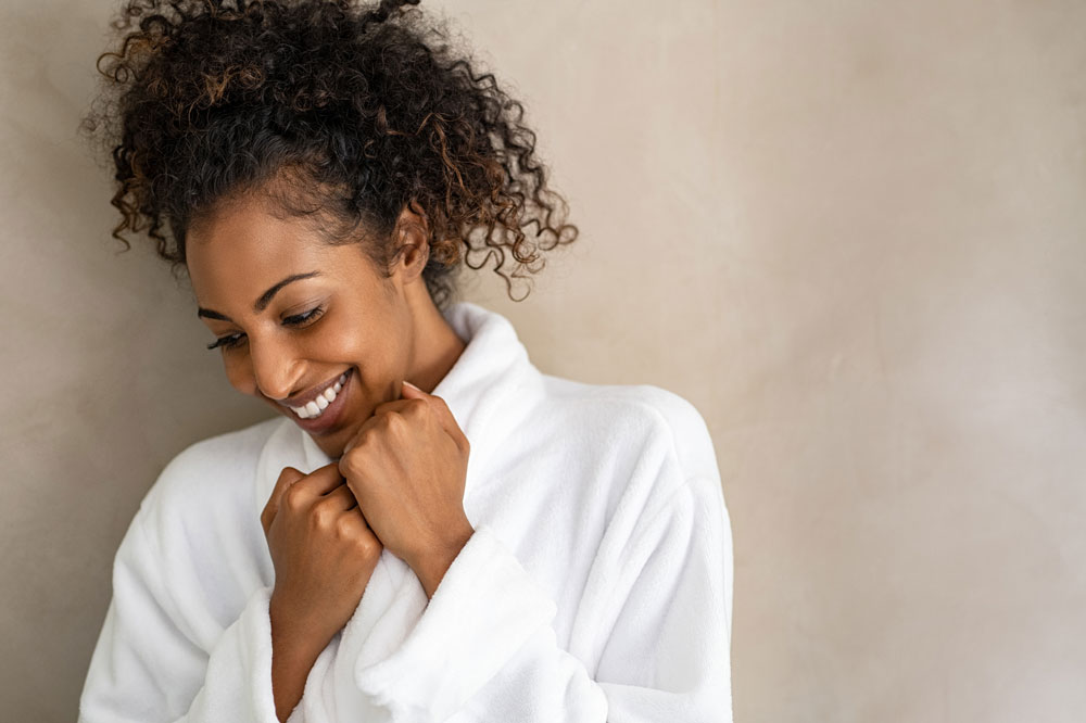 woman wearing white robe smiling