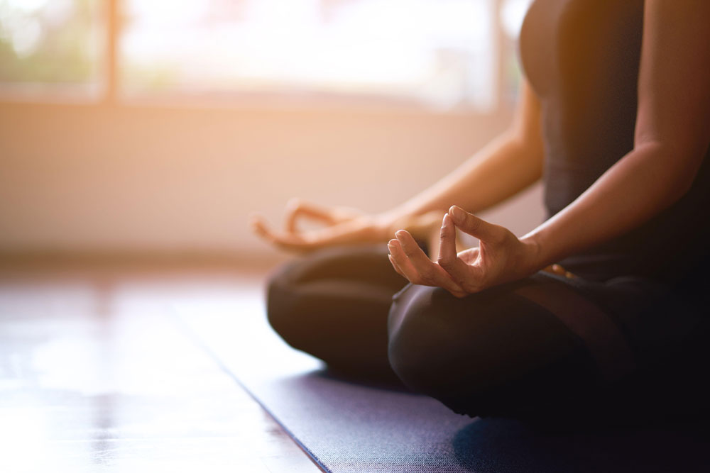 woman meditates on yoga mat