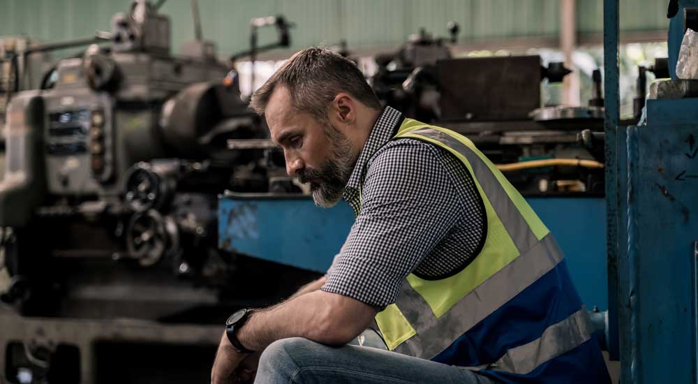 worker at factory looking sad