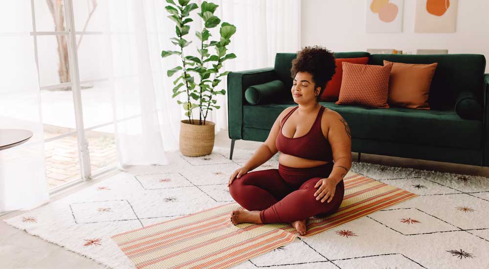 woman sitting crosslegged on yoga mat