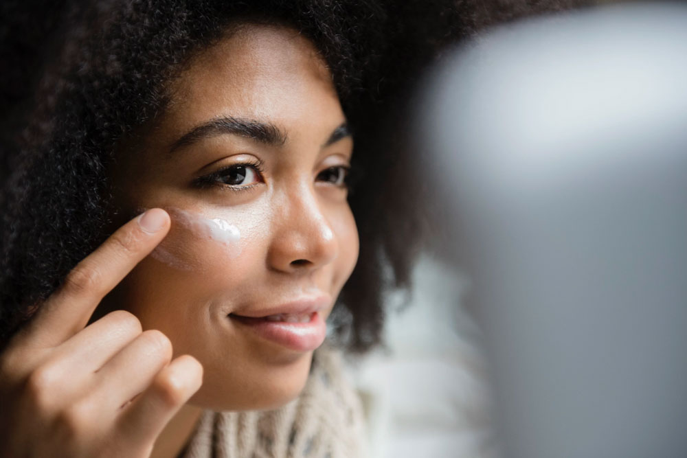 close up of woman with lotion around her eyes