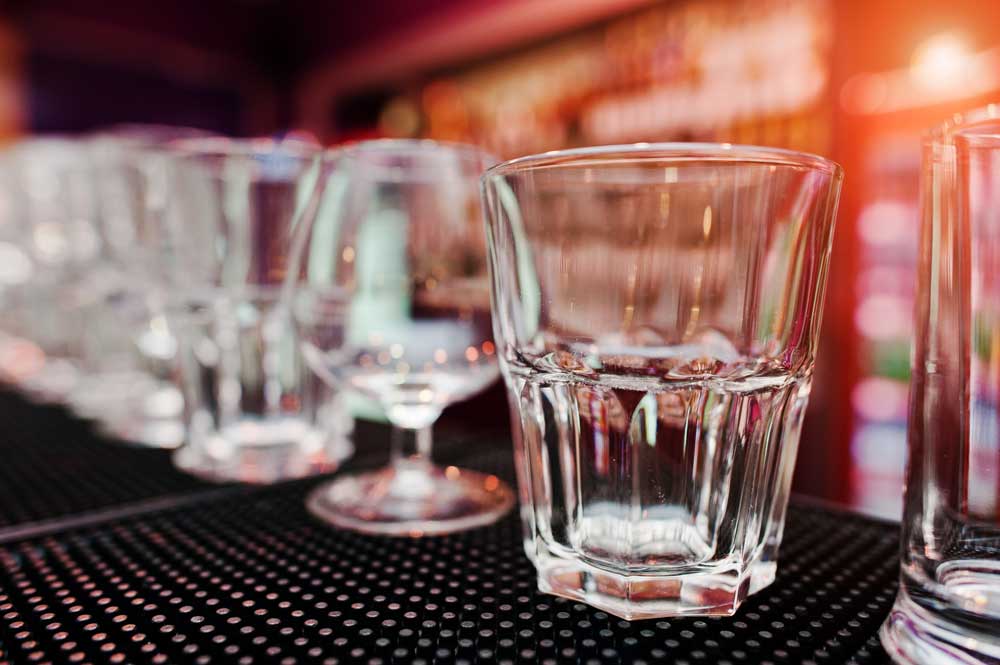 row of empty glasses on bar