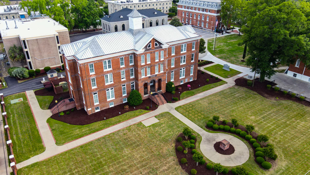 Overhead image of brick building with green grass quad