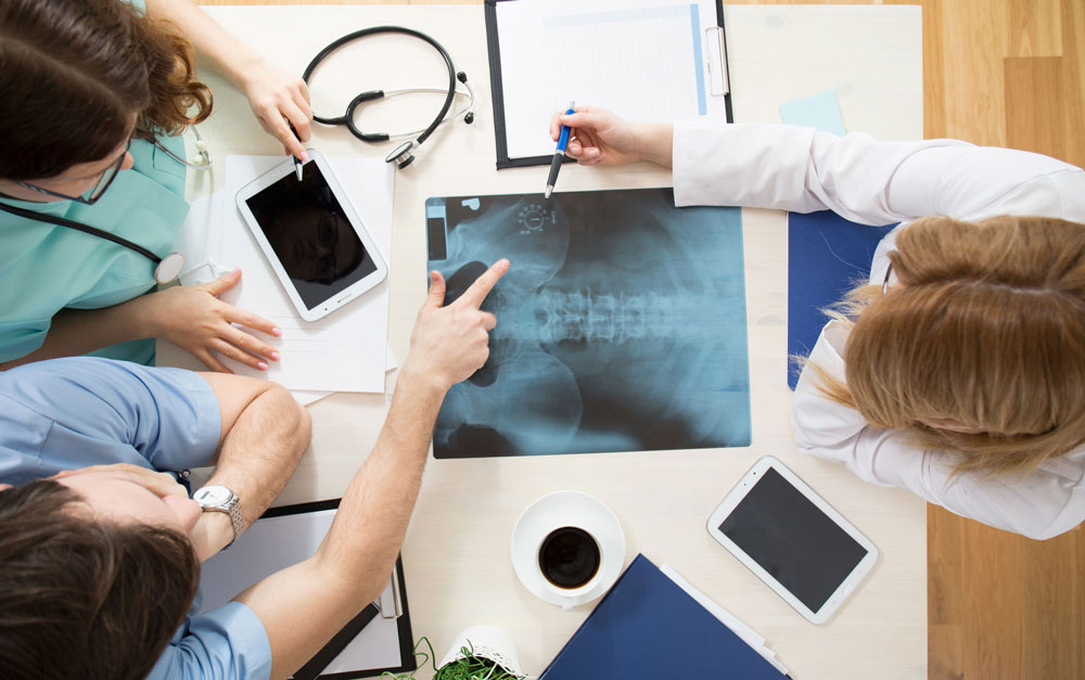 Doctors and nurses examine x-ray of spine