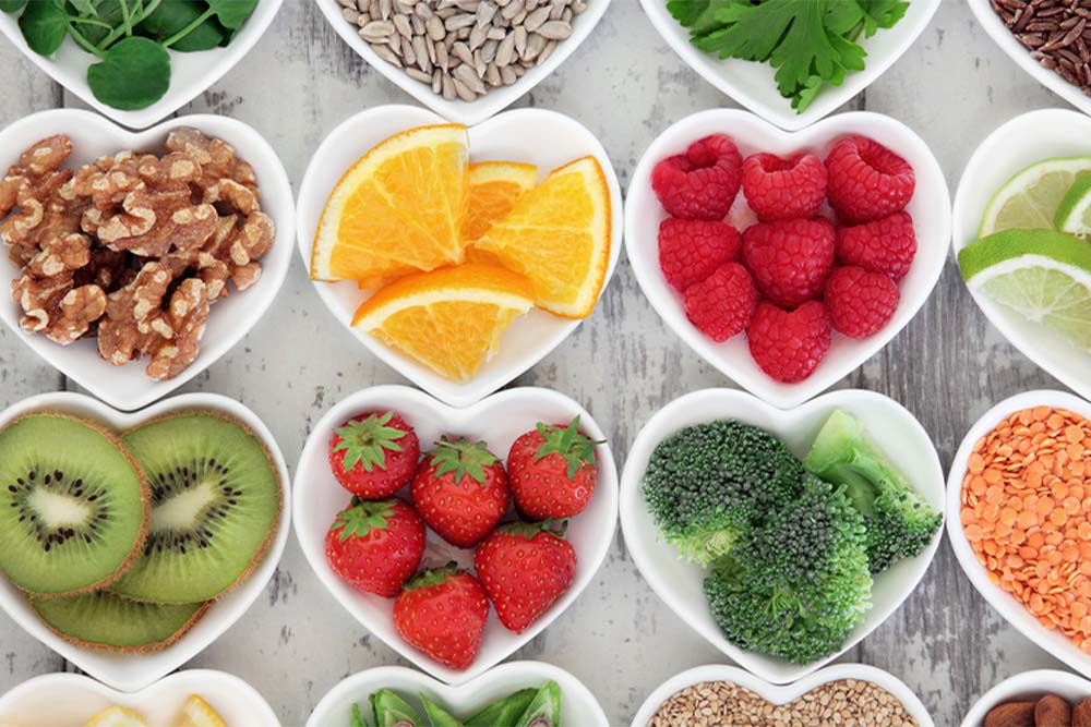 A collection of colorful fruits and vegetables arranged in heart-shaped bowls, showcasing a vibrant and healthy display.
