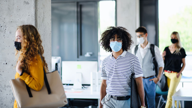 young man entering building with mask on